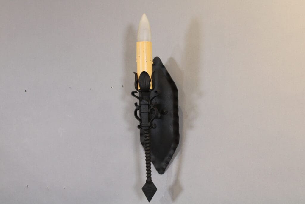 Wall-mounted medieval-style candle holder.