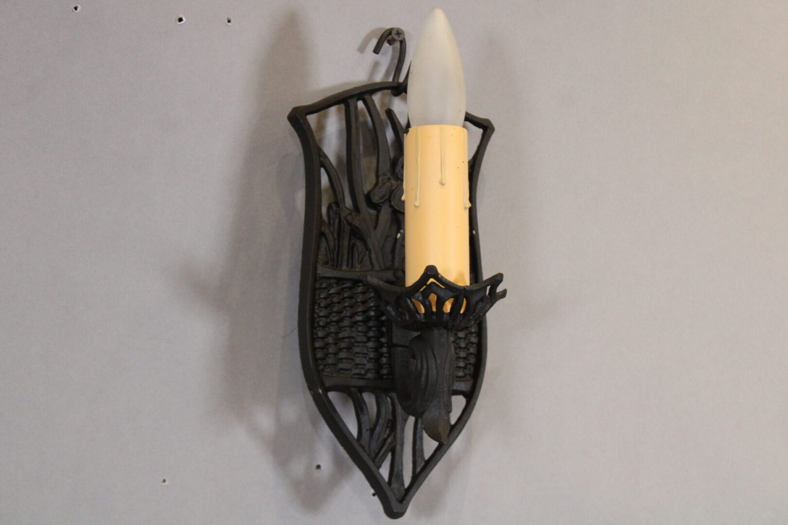 Vintage wall sconce with candle-shaped bulb.