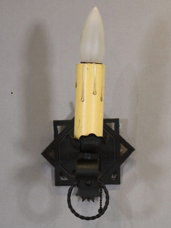 Vintage wall sconce with candle-shaped bulb.