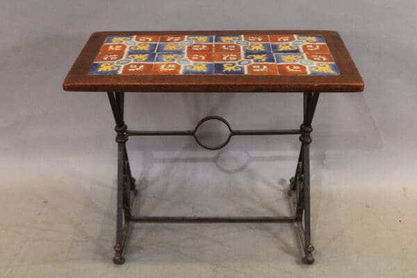 Colorful tiled table with decorative wrought iron base.