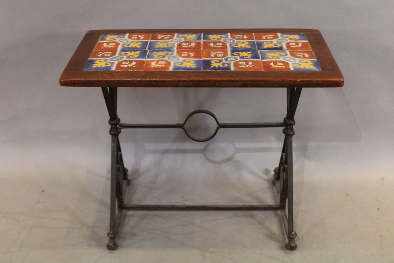 Colorful tiled table with decorative wrought iron base.