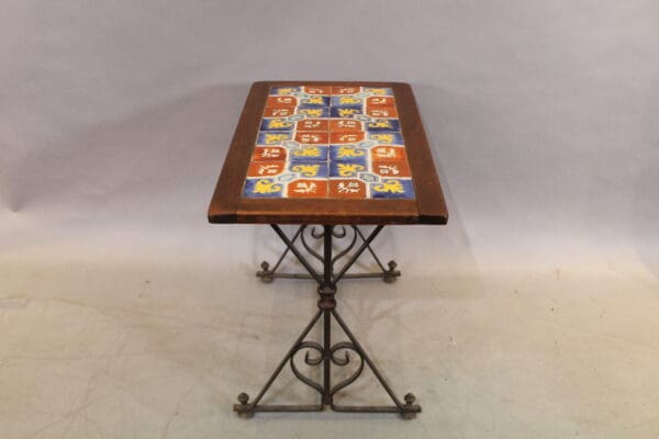 Colorful tiled table with wrought iron base.