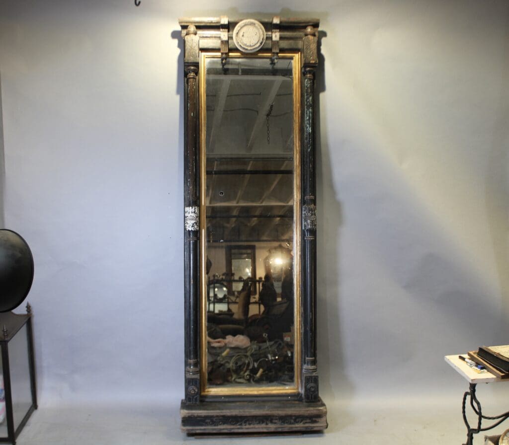 Tall vintage mirror with ornate wooden frame.
