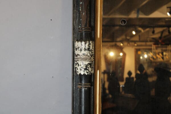 Antique mirror with ornate black frame.