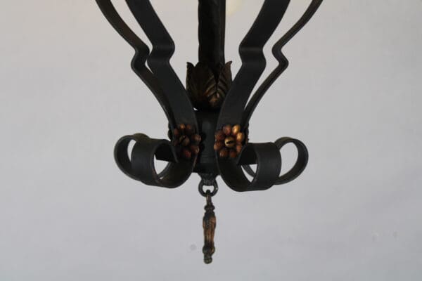 Ornate black metal chandelier with floral design.