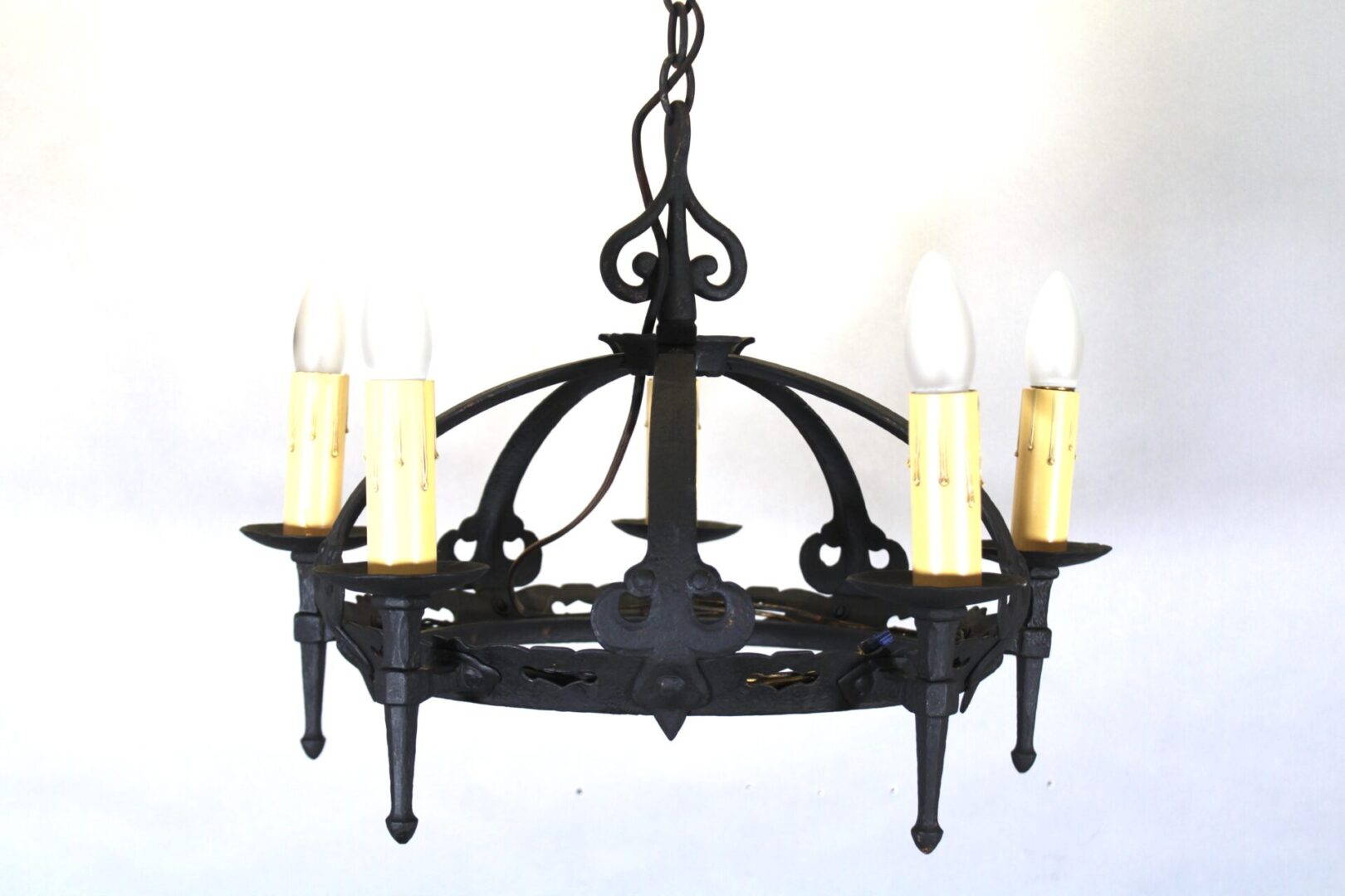 Wrought iron chandelier with candle-shaped bulbs.