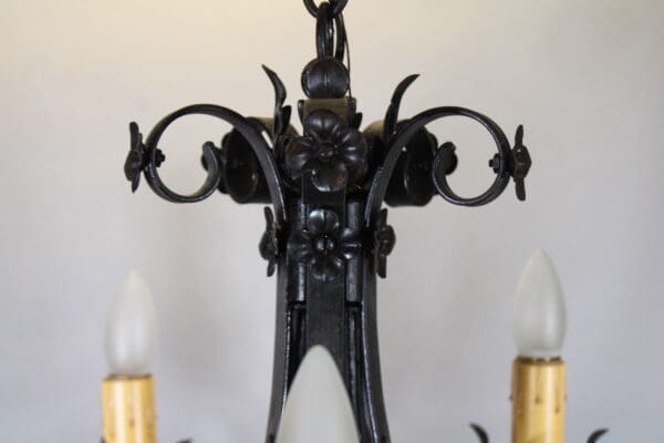 Ornate wrought iron chandelier with bulb candles.