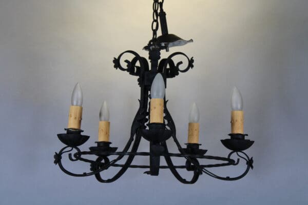 Ornate black chandelier with candle-shaped bulbs.