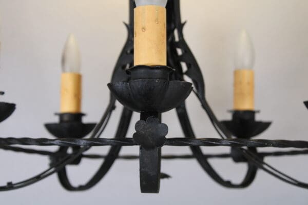 Black wrought iron chandelier with bulbs.