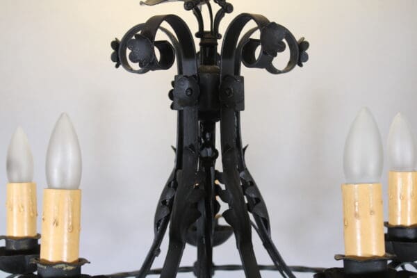 Vintage wrought iron chandelier with candle bulbs.