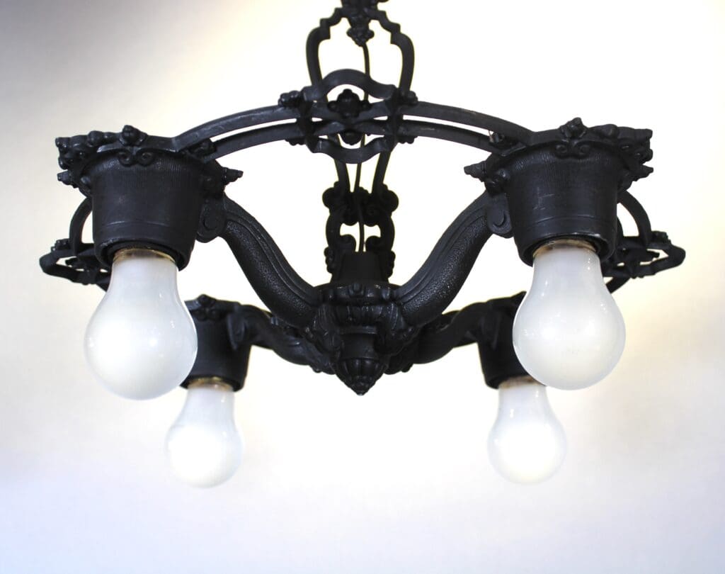 Vintage black chandelier with four light bulbs.
