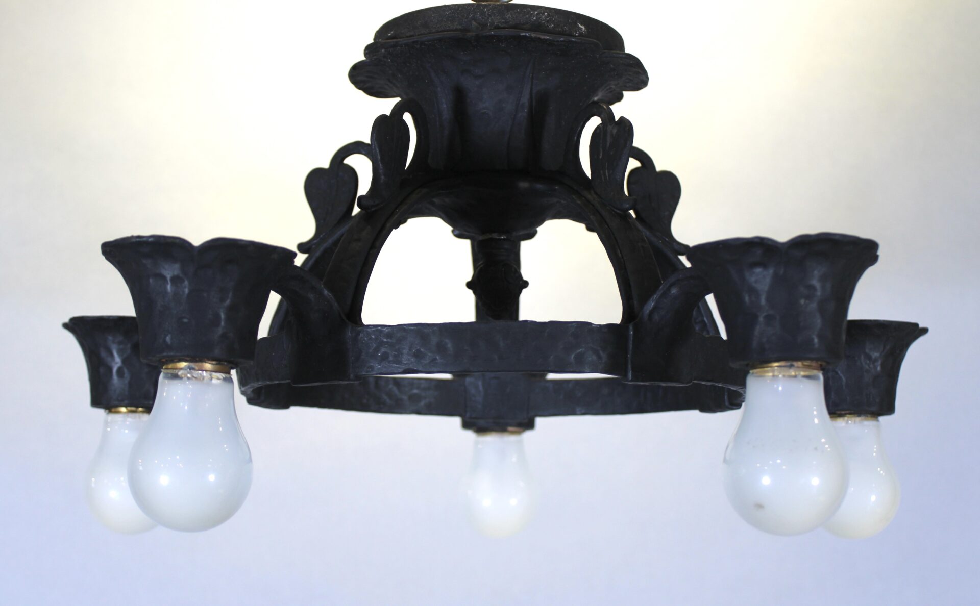 Vintage black metal chandelier with bulbs.