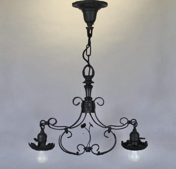 Vintage wrought iron chandelier with two bulbs.