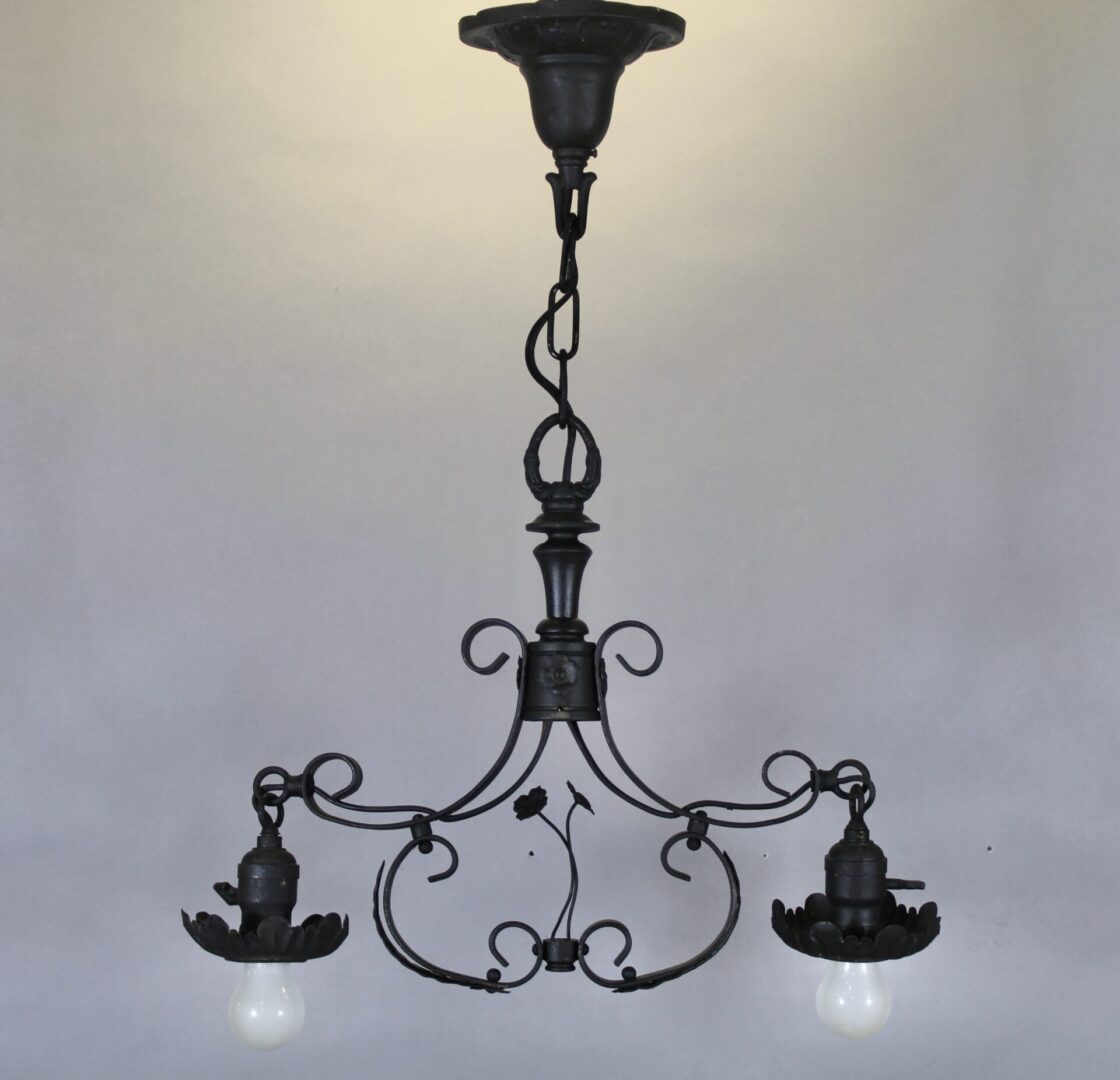 Vintage wrought iron chandelier with two bulbs.