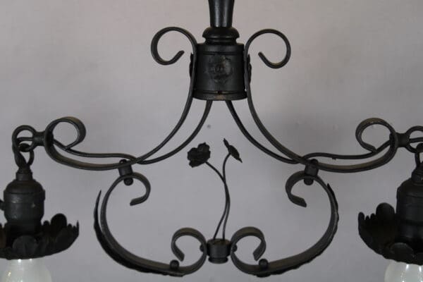 Ornate black metal chandelier with floral design.