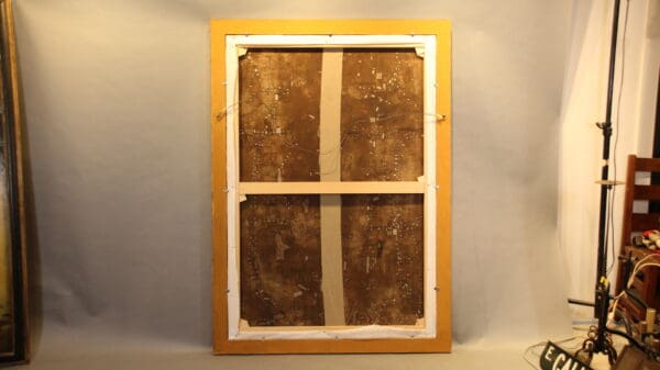 Back of a framed painting in studio.