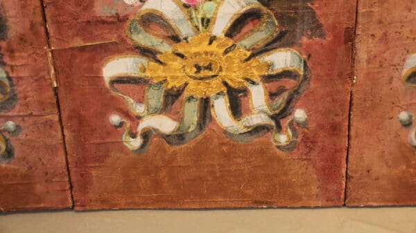 Painted floral design on textured surface.