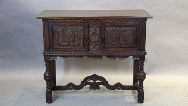 Antique wooden side table with ornate carvings.