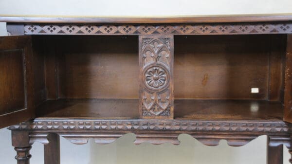 Ornate wooden cabinet with open doors.