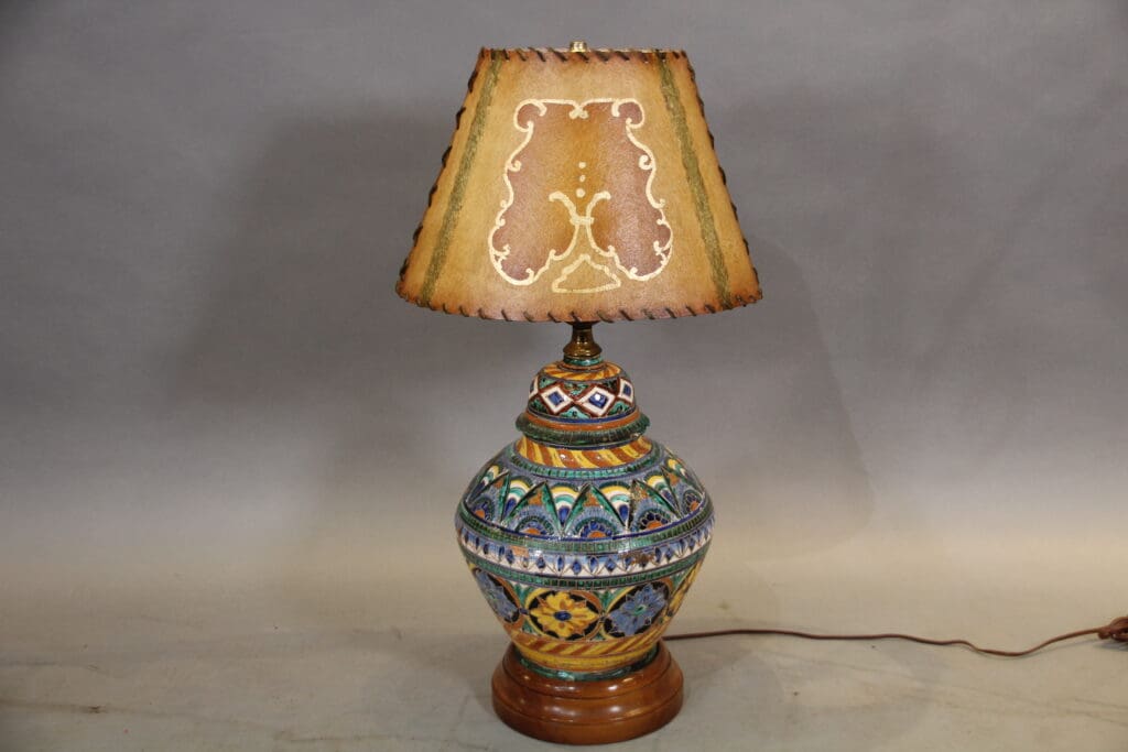 Colorful ceramic lamp with decorated shade.