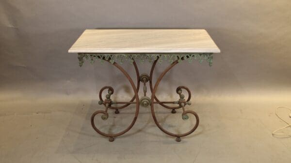 Decorative wrought iron table with ornate base.