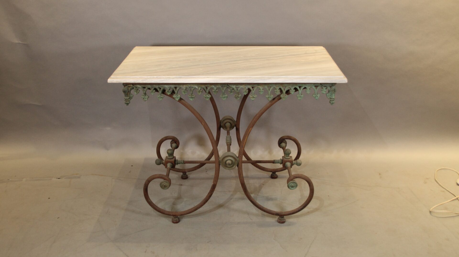 Decorative wrought iron table with ornate base.