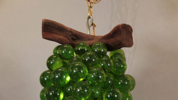 Green glass grape cluster with wooden stem.