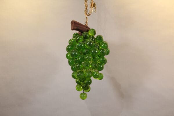 Green glass grape cluster with wooden stem.