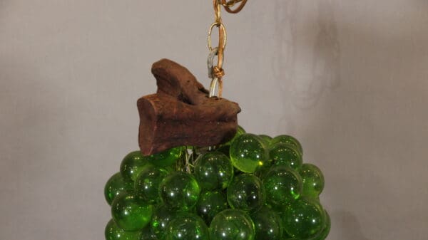 Green glass grapes with wooden stem decoration.
