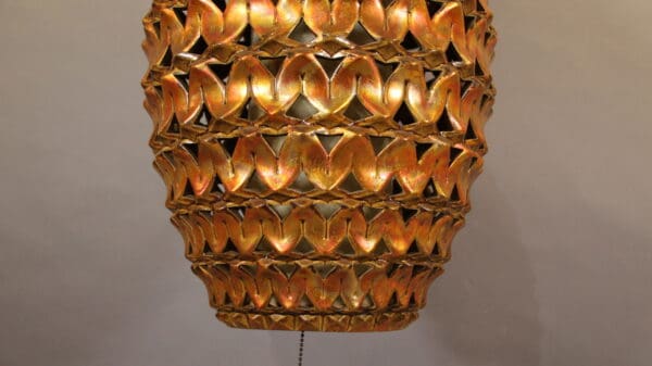 Golden decorative hanging lamp with intricate design.