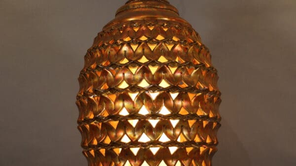 Ornate golden lamp with intricate pattern.