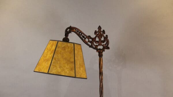 Ornate lamp with a yellow lampshade.