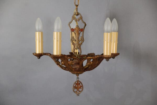 Vintage chandelier with five candle-shaped lights.