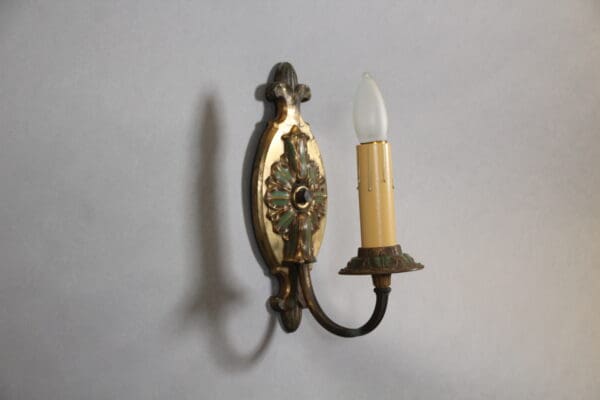 Vintage ornate wall sconce with candle bulb.