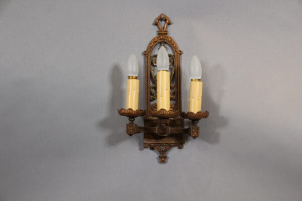 Vintage three-light wall sconce with bulbs.