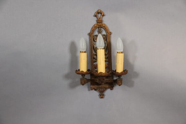 Vintage ornate wall sconce with three bulbs.