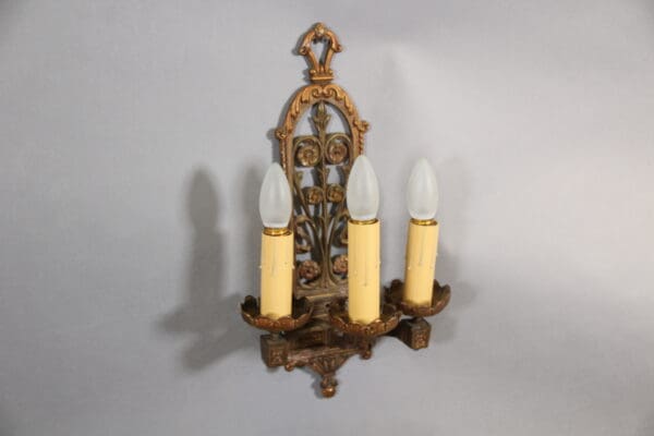 Vintage three-light decorative wall sconce fixture.