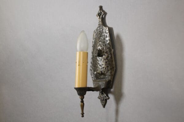 Vintage wall sconce with candle-shaped bulb.