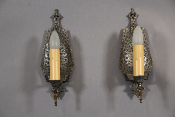 Two ornate wall sconces with candle bulbs.