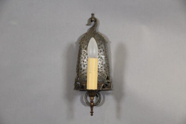 Vintage wall sconce with candle-shaped bulb.