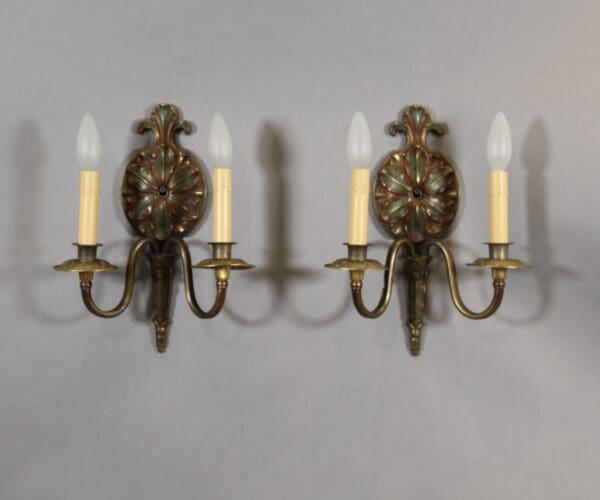 Vintage dual-arm wall sconces with candles.