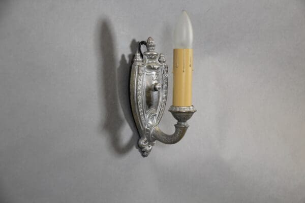 Vintage wall sconce with candle-shaped bulb.