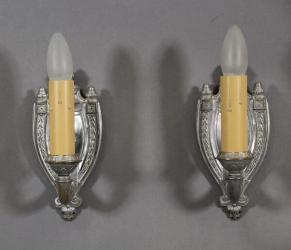 Two vintage wall sconces with candle bulbs.