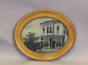 Oval framed vintage storefront with horse carriage