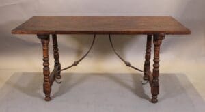 Antique wooden table with turned legs in light bg