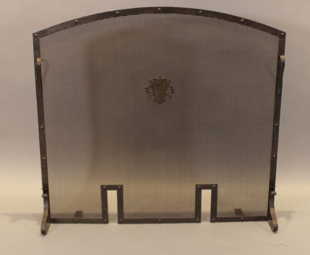 Arched metal fireplace screen with crest