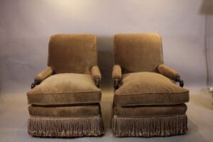 Pair of vintage upholstered armchairs with fringe.